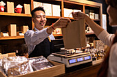 Smiling chocolatier serving customers
