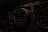 Aged wine bottles in wooden barrels in the wine cellar of Kakheti