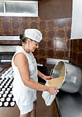 Baker filling dough into a piping bag