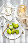 Brie cheese with fresh figs and honey from above on a sunny table