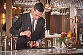 Männlicher Barkeeper bei der Zubereitung eines Cocktails in einer Bar