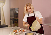 Woman prepares a cake in a modern kitchen