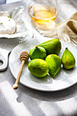 Green figs and creamy brie cheese on a bright white plate