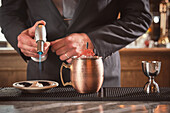 Ein Barmann brennt Baiser für einen Cocktail auf dem Tresen