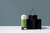 Refreshing matcha tea with whipped cream against an elegant backdrop