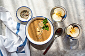 Top view of healthy dinner set with mushroom cream soup and apple water