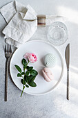 Elegantly laid table with roses and pastel-coloured macarons
