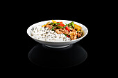 Exquisite Asian food in a white bowl on a black background