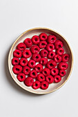 Fresh raspberries in a cream-colored ceramic bowl