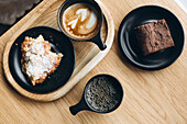 Varied selection of breakfast treats and coffees on a wooden table