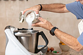 Man puts sugar in the mixer for an Epiphany cake