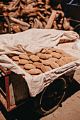 Traditional Moroccan bread on a trolley with firewood in the background