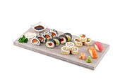 Different types of sushi on a smooth wooden board