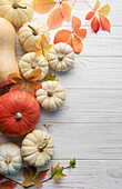 Herbstblätter und Kürbisse vor altem Holzhintergrund