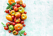 Colourful assortment of ripe tomatoes on a textured surface with