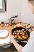 Private chef preparing a fish dish in a cosy kitchen at home