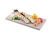 Variety of sushi rolls and sashimi on a wooden board