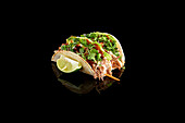 Delicious Asian tacos with fresh coriander and lime on a black background