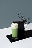 Matcha iced tea with whipped cream against a modern backdrop