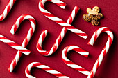 Top view of festive candy canes and butter cookies on red