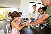 Family baking biscuits together in a modern kitchen