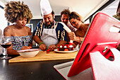 A group of friends bake and decorate a cake together