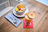 Healthy fruit bowl and flavoured drink on a wooden breakfast table