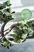 Top view of elegant table setting with feijoa and green glass