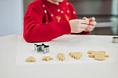 Child bakes Christmas biscuits in a festive atmosphere