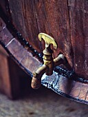 Traditional Mallorcan liqueur Palo dripping from a wooden barrel