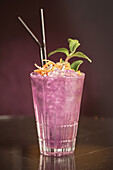 Pink cocktail with ice cubes in glass on counter