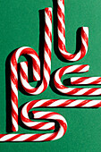 Candy canes against a green background, photographed from above