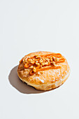 Vegan donut with carrot cake filling, glaze and nut topping