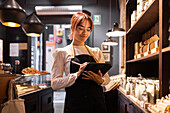 Shop assistant arranging chocolates in a shop