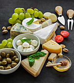 Various cheeses, grapes, honey and snacks