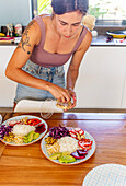 Woman prepares vegan poke bowls during a cookery workshop
