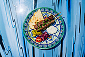 Beef kebab with garnishes on a colorful plate in Beirut