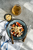 Top view of Mediterranean salad with white wine on table