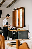 Private chef preparing salami in a rustic domestic kitchen