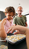 Father and daughter bake biscuits together