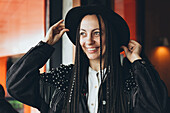 Stylish Caucasian woman with pigtails smiles in a cafe