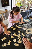 Young girls baking biscuits in a lively kitchen