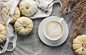 Autumnal composition. Cosy atmosphere at home. White pumpkins, coffee