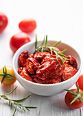 Schale mit sonnengetrockneten Tomaten mit frischen Kräutern und Gewürzen