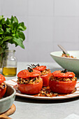 Stuffed tomatoes with brown rice and herbs on ceramic plate