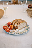 Elegant dining setup with freshly sliced bread and tomatoes