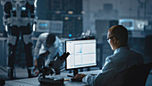 Scientist using computer in robotics lab