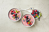 Pink smoothie bowl with avocado, berries and coconut water