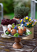 Kleine Sträuße aus Narzissen, Traubenhyazinthen, Frühlingsknotenblume in Eierschalen als Vase