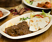 Lamb madras curry with naan, rice and salad